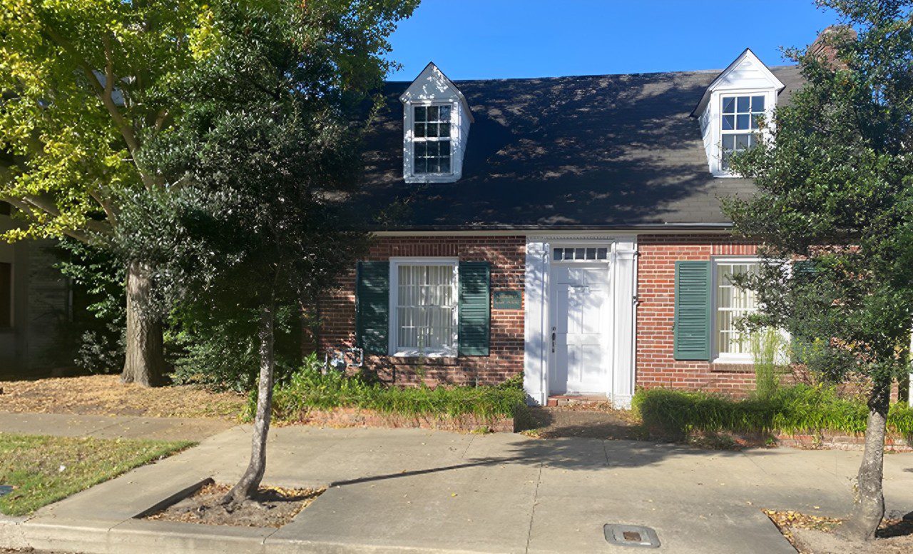 A Cozy Brick House With Shutters and Trees.